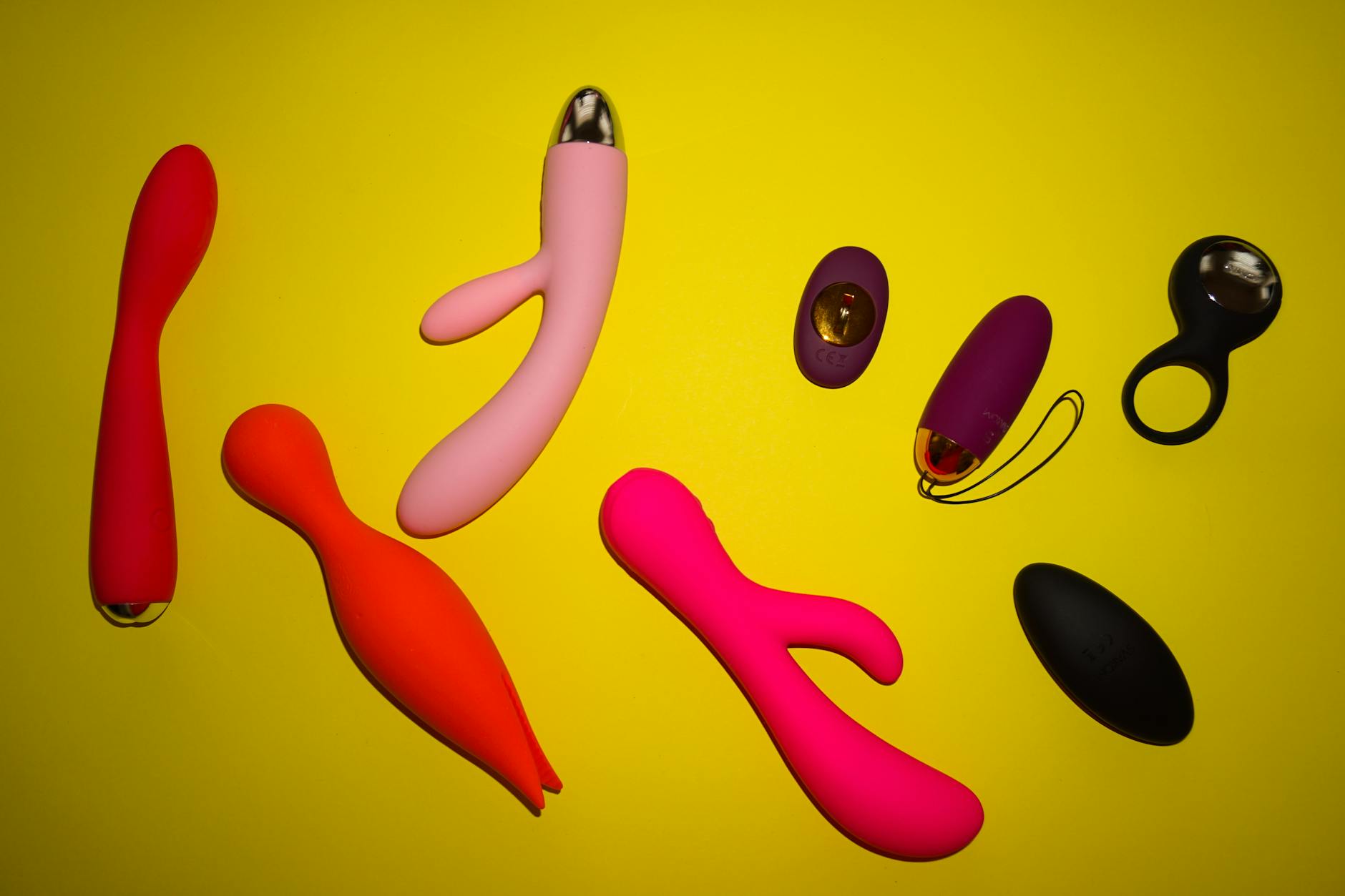 Hand holding a vibrator against a minimalist purple background, showcasing modern sexual wellness tools